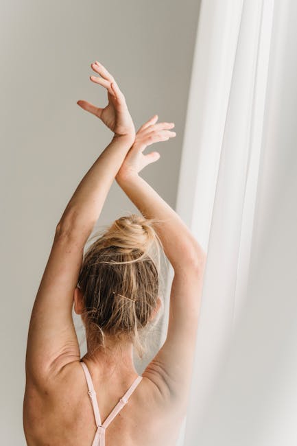 Woman performing a gentle yoga stretch in a sunlit room